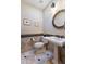 Half bath with a pedestal sink, decorative mirror, tiled floors, and a wall-mounted toilet paper holder at 5512 E Barwick Dr, Cave Creek, AZ 85331