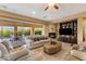 Cozy living room with a fireplace, built-in shelving, and patio access to the pool at 5512 E Barwick Dr, Cave Creek, AZ 85331