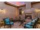 Enclosed outdoor patio with fireplace, travertine flooring, and cozy seating for entertaining at 5512 E Barwick Dr, Cave Creek, AZ 85331