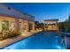 Beautiful backyard pool with a covered patio and built-in grill at twilight at 5512 E Barwick Dr, Cave Creek, AZ 85331