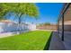 Backyard with artificial turf and gravel landscaping, fenced for privacy and security at 5534 W Calavar Rd, Glendale, AZ 85306