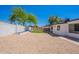 Backyard featuring gravel landscaping, a small patch of artificial turf, and a covered patio area at 5534 W Calavar Rd, Glendale, AZ 85306