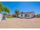 Backyard with gravel landscaping, a patch of artificial turf, and a covered patio at 5534 W Calavar Rd, Glendale, AZ 85306
