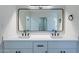 Bright bathroom featuring dual sinks, modern fixtures, a large mirror, and a neutral color palette at 5534 W Calavar Rd, Glendale, AZ 85306