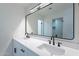 Modern bathroom featuring double sinks with matte black fixtures, a large mirror, and white cabinets at 5534 W Calavar Rd, Glendale, AZ 85306