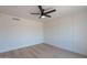 This bedroom features a ceiling fan, a modern accent wall, and wood-look flooring at 5534 W Calavar Rd, Glendale, AZ 85306