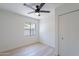 Bright bedroom with light wood floors, a ceiling fan, and a window overlooking the backyard at 5534 W Calavar Rd, Glendale, AZ 85306