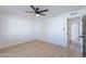 Bedroom with light wood floors, modern wall paneling and ceiling fan at 5534 W Calavar Rd, Glendale, AZ 85306