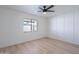 Bedroom with light wood floors, ceiling fan, window, white walls and trim, and modern wall paneling at 5534 W Calavar Rd, Glendale, AZ 85306