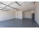 Spacious two-car garage with painted walls and floor and an electric door opener at 5534 W Calavar Rd, Glendale, AZ 85306