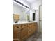 Bathroom with double sinks, wood cabinets, and updated hardware at 5952 W Morning Dove Dr, Glendale, AZ 85308