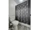 Bathroom showing toilet and shower with patterned curtain at 5952 W Morning Dove Dr, Glendale, AZ 85308