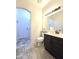 Bathroom with a dark vanity, large mirror, and light gray flooring at 5952 W Morning Dove Dr, Glendale, AZ 85308
