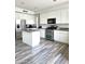 Well-lit kitchen with white cabinets, granite countertops, stainless steel appliances, and breakfast bar island at 5952 W Morning Dove Dr, Glendale, AZ 85308
