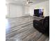 Bright living room featuring wood-look floors, a ceiling fan, and a large tv on a floating entertainment center at 5952 W Morning Dove Dr, Glendale, AZ 85308