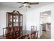 Classic dining room featuring an elegant china cabinet, a ceiling fan, and views into kitchen at 6 E Piping Rock Rd, Phoenix, AZ 85022