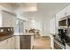 Modern kitchen with white cabinets, granite countertops, stainless steel appliances, and an adjacent dining space at 6 E Piping Rock Rd, Phoenix, AZ 85022