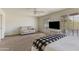 Spacious bedroom with seating area, ceiling fan, and bright view at 6 E Piping Rock Rd, Phoenix, AZ 85022