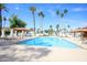 Inviting community pool surrounded by palm trees and comfortable lounge chairs at 6 E Piping Rock Rd, Phoenix, AZ 85022