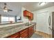 Galley kitchen showcases granite countertops and wooden cabinets; a breakfast bar connects it to the open-concept living space at 623 W Guadalupe Rd # 213, Mesa, AZ 85210