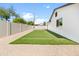 Fully fenced backyard featuring low maintenance artificial turf and desert landscaping at 6332 W Sunnyslope Ln, Glendale, AZ 85302