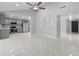 Open-concept living room with modern tile flooring, ceiling fan, and easy access to the kitchen at 6332 W Sunnyslope Ln, Glendale, AZ 85302