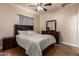 Comfortable bedroom with a queen-sized bed, tiled floors, ceiling fan, and dresser at 6459 W Columbus Ave, Phoenix, AZ 85033