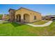 Charming home featuring a stone pillar porch, yellow stucco exterior, and well-maintained lawn at 6459 W Columbus Ave, Phoenix, AZ 85033