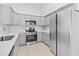 Modern kitchen featuring stainless steel appliances, gray cabinets, and neutral tile flooring at 6908 W Sierra St, Peoria, AZ 85345