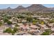 Scenic aerial perspective of a residential neighborhood featuring mature landscaping, diverse home styles, and distant mountain vistas at 6988 W Monte Lindo --, Glendale, AZ 85310