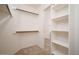 Walk-in closet featuring built-in shelving and carpet flooring at 6988 W Monte Lindo --, Glendale, AZ 85310