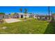 An inviting backyard with a well-maintained lawn, a cozy fire pit, and shady palm trees at 7011 W Carol Ann Way, Peoria, AZ 85382