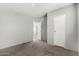 This carpeted bedroom has light gray walls, leading to a closet door, and a glimpse into another room at 7011 W Carol Ann Way, Peoria, AZ 85382