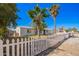 Attractive single-story home with a white picket fence and mature shade trees in a well-maintained yard at 7011 W Carol Ann Way, Peoria, AZ 85382