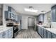 Modern kitchen featuring stainless steel appliances, light blue cabinetry, and abundant natural light at 7011 W Carol Ann Way, Peoria, AZ 85382