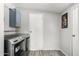 Laundry room with gray wood flooring, a gray washing machine, and dryer unit underneath a cabinet at 7011 W Carol Ann Way, Peoria, AZ 85382