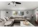 Bright living room featuring a comfortable sectional sofa, neutral decor, and natural light at 7011 W Carol Ann Way, Peoria, AZ 85382