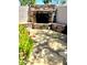 Outdoor fireplace with stacked stone surround, built-in benches, and stone pavers at 7111 S 21St Dr, Phoenix, AZ 85041