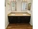 Bathroom with double sinks, granite countertops, and dark wood cabinets at 7111 S 21St Dr, Phoenix, AZ 85041