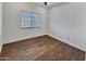 Bedroom with modern wood-look floors, a ceiling fan and a window with horizontal blinds at 7111 S 21St Dr, Phoenix, AZ 85041