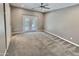 Spacious bedroom featuring soft carpet, ceiling fan, and french doors to the backyard at 7111 S 21St Dr, Phoenix, AZ 85041
