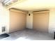 Garage featuring two tan roll-up security doors, concrete floor, and small pet door at 7111 S 21St Dr, Phoenix, AZ 85041