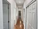 Bright hallway featuring wood floors, white walls, and multiple doors at 7111 S 21St Dr, Phoenix, AZ 85041