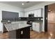 Well-lit kitchen with white cabinets, granite countertops, stainless steel appliances, and an island at 7111 S 21St Dr, Phoenix, AZ 85041