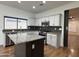 Bright kitchen featuring white cabinets, gray granite countertops, stainless steel appliances, and center island at 7111 S 21St Dr, Phoenix, AZ 85041