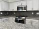 Close-up of a modern kitchen with a stainless steel range, granite countertops, and white cabinets at 7111 S 21St Dr, Phoenix, AZ 85041