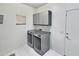 Bright laundry room with new front-load washer and dryer and storage cabinets at 7111 S 21St Dr, Phoenix, AZ 85041