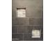 Close-up of tiled shower with built-in niche for toiletries and mosaic tile accents at 7111 S 21St Dr, Phoenix, AZ 85041