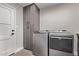 Laundry room includes gray cabinets and modern washer and dryer at 7962 E San Miguel Ave, Scottsdale, AZ 85250