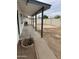 Backyard featuring covered patio, dirt yard, block fence, and glimpses of the pool at 845 N Los Alamos Dr, Goodyear, AZ 85338